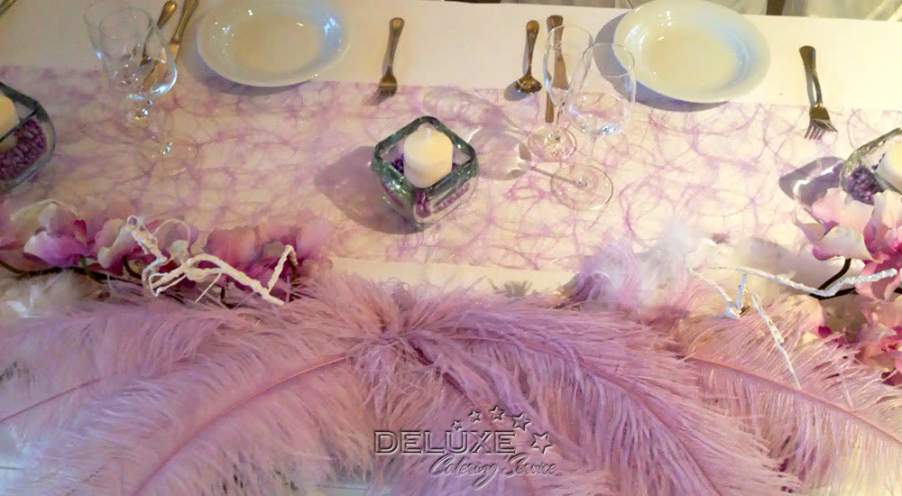 Zarte Federdeko in Rosé auf der Tafel